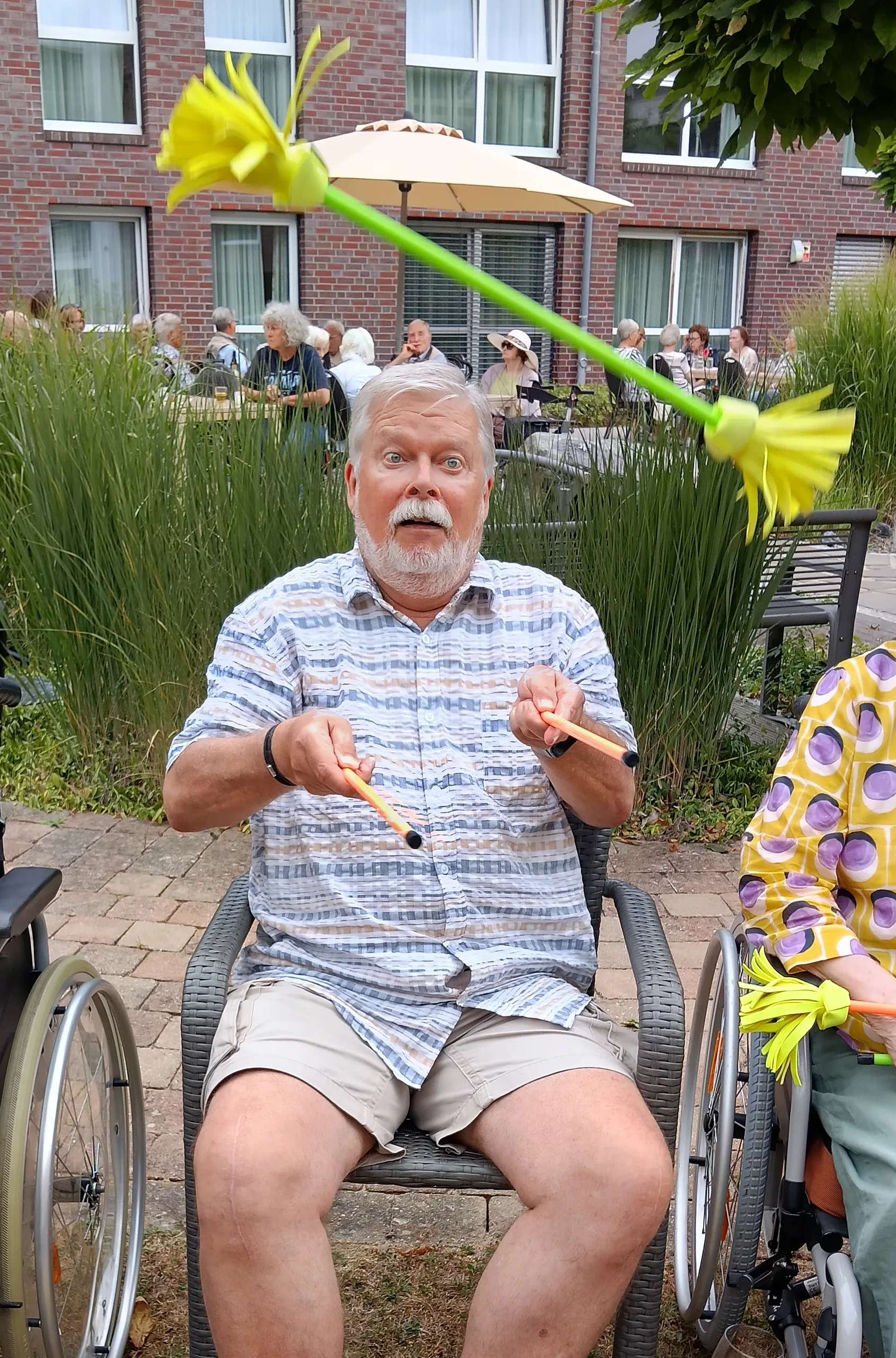 Ein Bewohner probiert im Sitzen einen Flowerstick aus